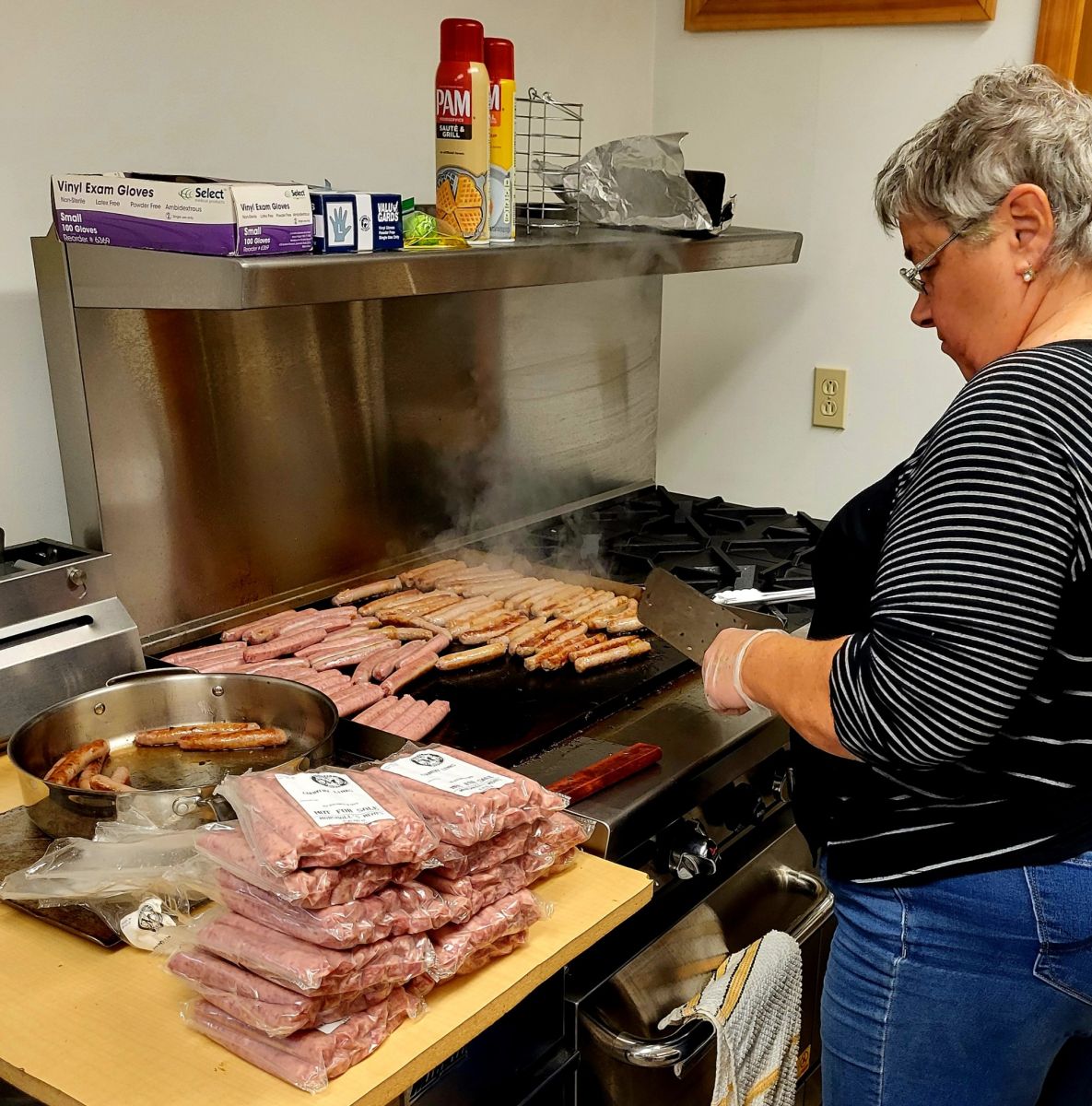 Penny Holland prepares sausage donated by Marshall's Meats from Winchester, ID